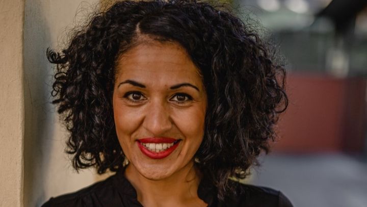 Eine Frau schaut freundlich in die Kamera.