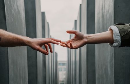 von links und von rechts sieht man zwei Unterarme, deren Fingerspitzen