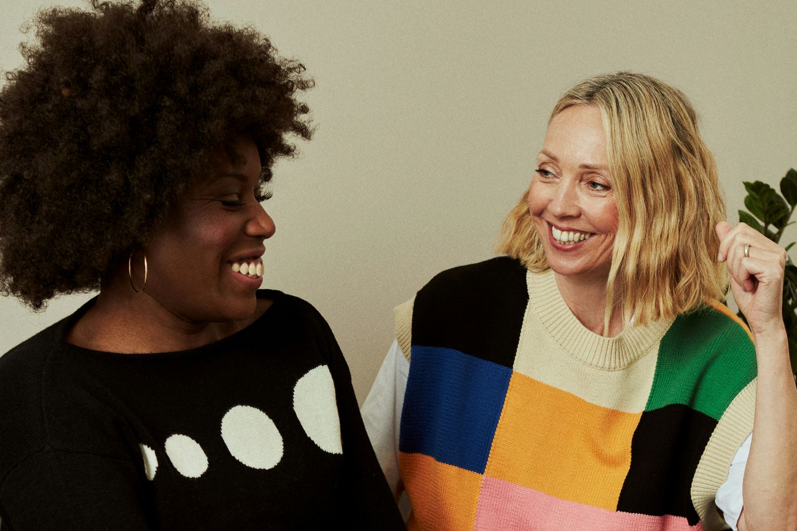 Ev_Medienakademie_Vielfaltskompetenz_2026 zwei Frauen unterschiedlicher Hautfarbe sitzen zugewandt nebeneinander lachen