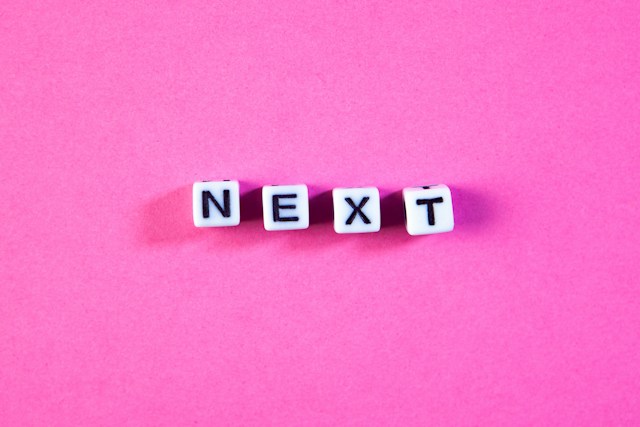 Sasun Bughdaryan/ unsplash auf pinkem Hintergrund das Wort next mit Buchstabenwürfeln gelegt